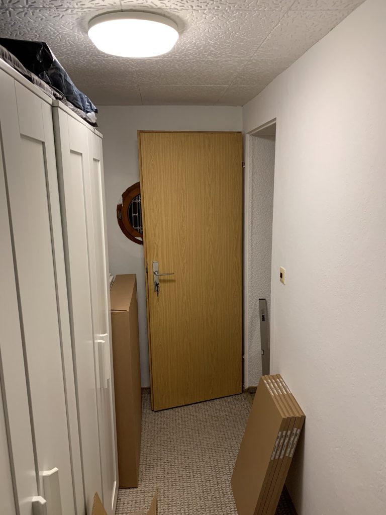 Die Farbe der alten Tür harmoniert hervorragend mit den davor stehenden Kartons