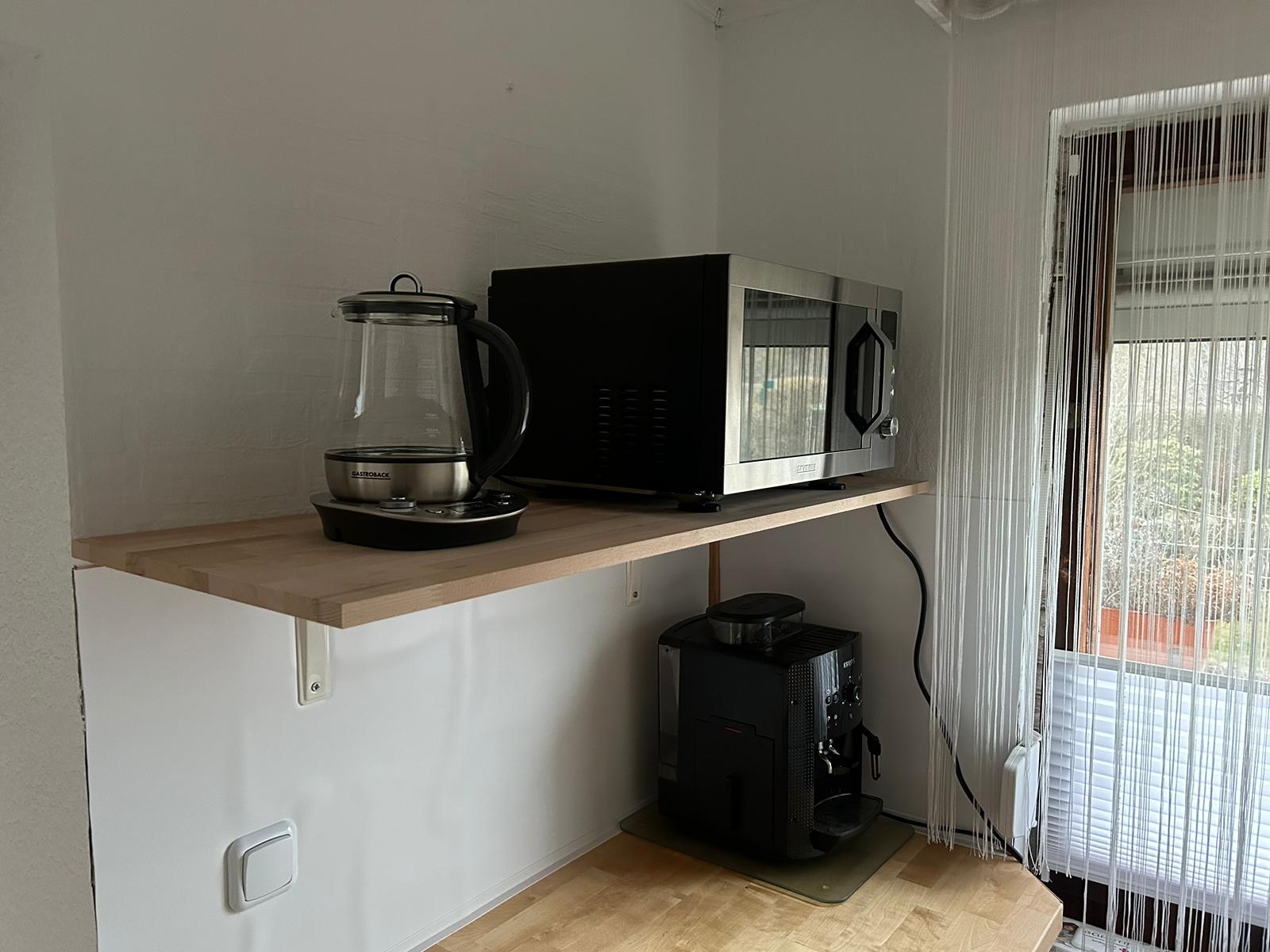 Wasserkocher und Mikrowellengrill oben, Kochfeld und Kaffeeautomat unten