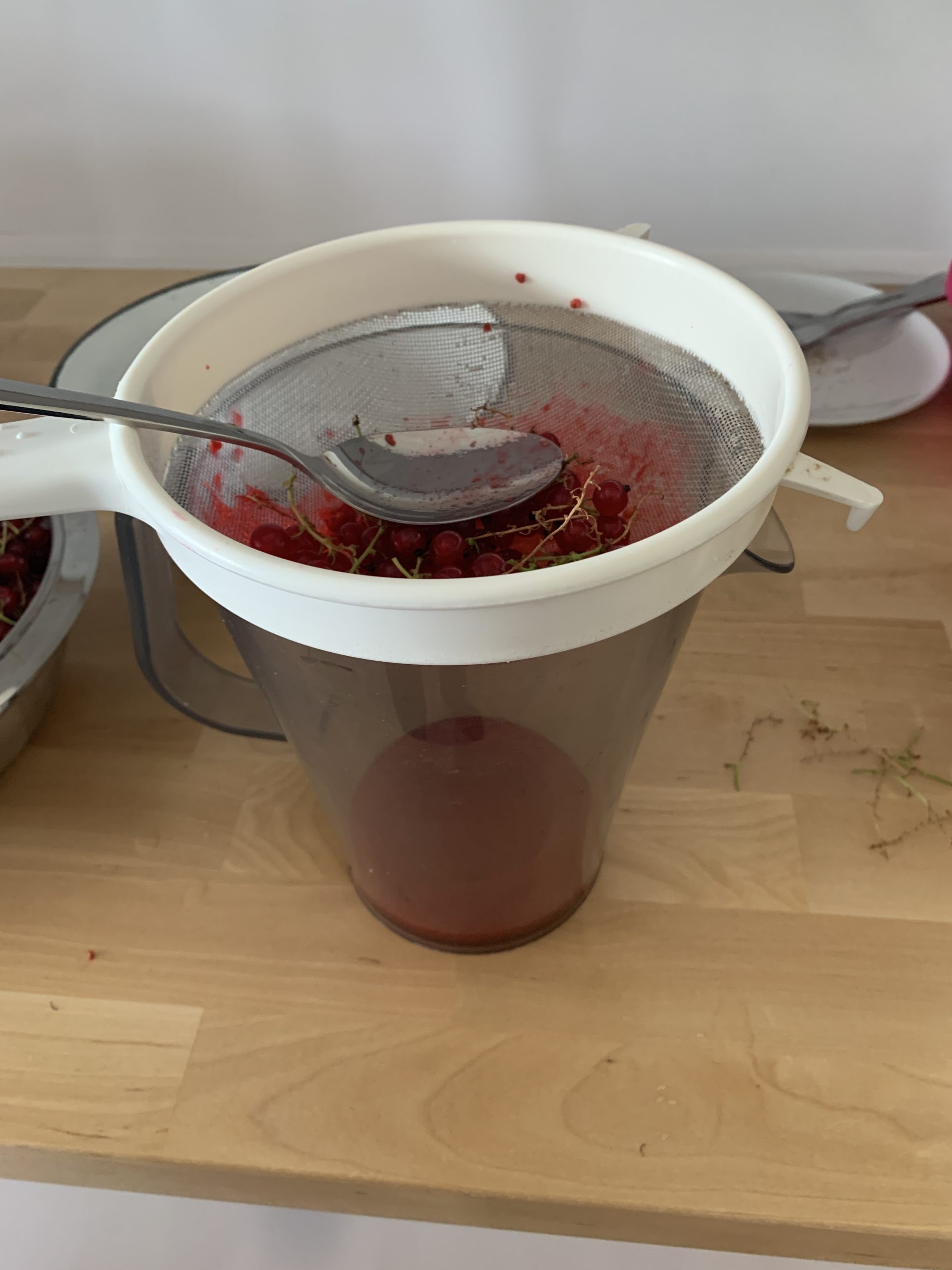 Auspressen der Früchte per Hand, Sieb und Löffel