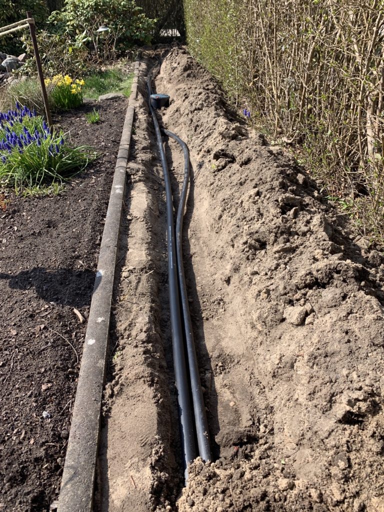 Ein Graben, zwei Leitungen entlang des Gartenteichs