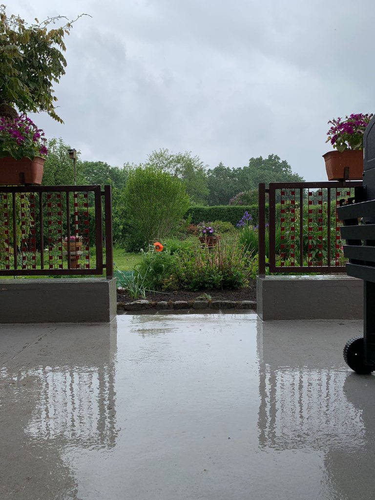 Grau - Grün - Grau (Himmel - Garten - Terrasse): Ein starker Regenschauer setzte unseren Garten am Abend des 24. Mai unter Wasser